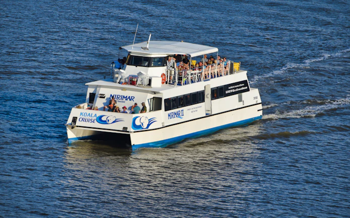 Brisbane River cruise boat heading to Lone Pine Koala Sanctuary with passengers on board.