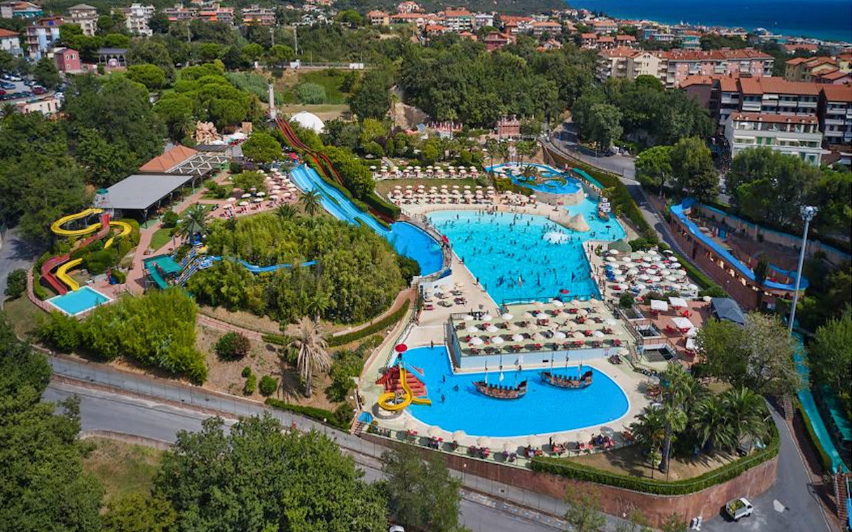 Caravelle Aquapark aerial view with pools, slides, and surrounding greenery in Italy.