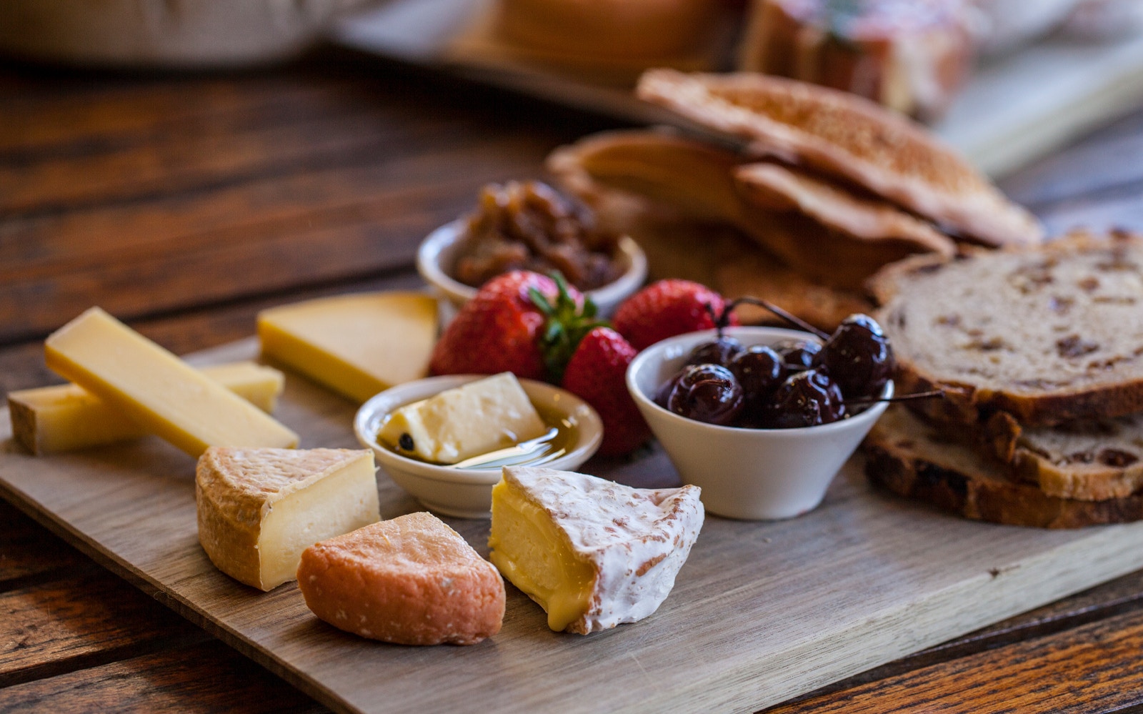 Gourmet cheese platter with fruits and bread on Bruny Island tour.