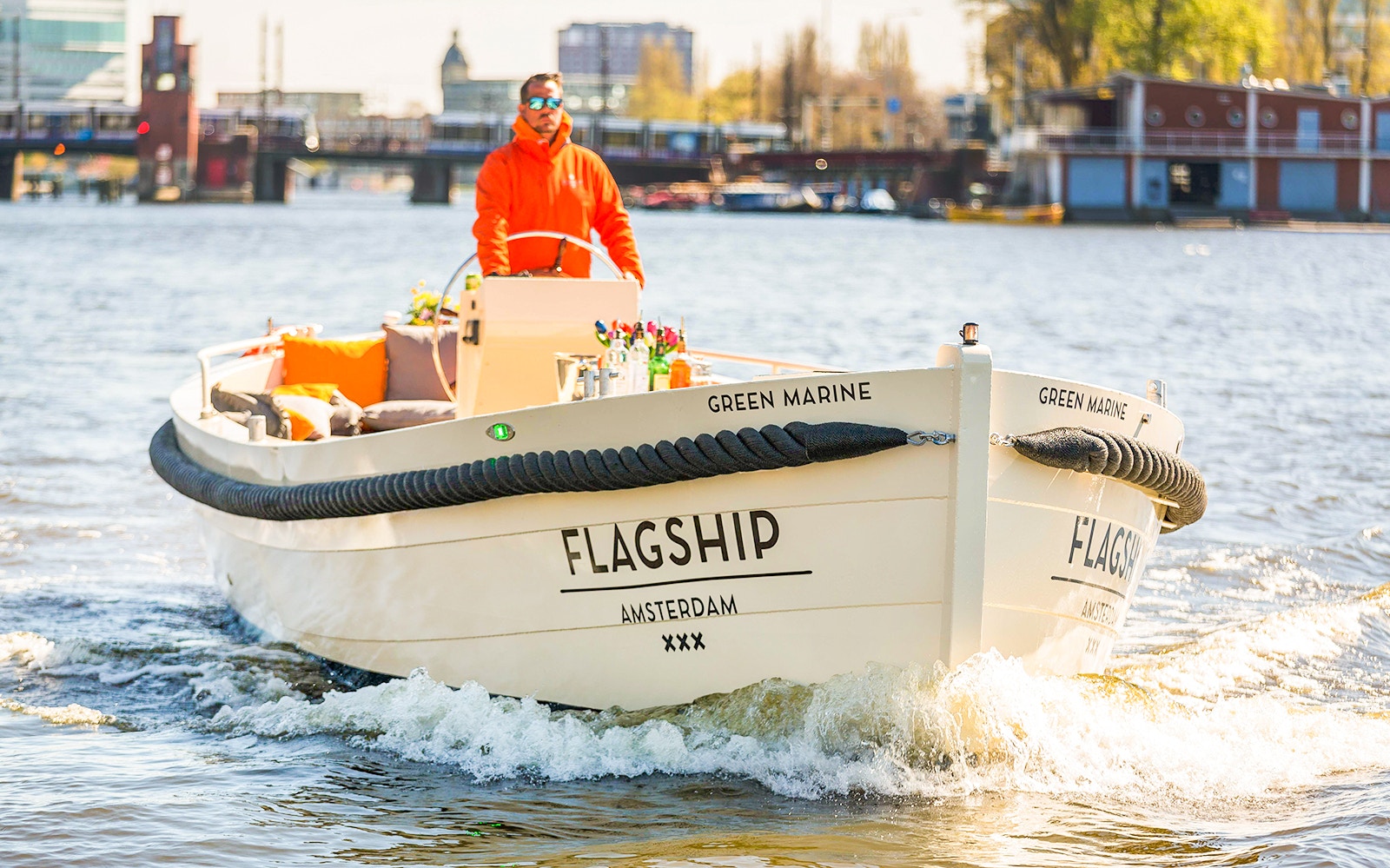 Amsterdam canal cruise boat with passengers enjoying unlimited drinks near Anne Frank House.