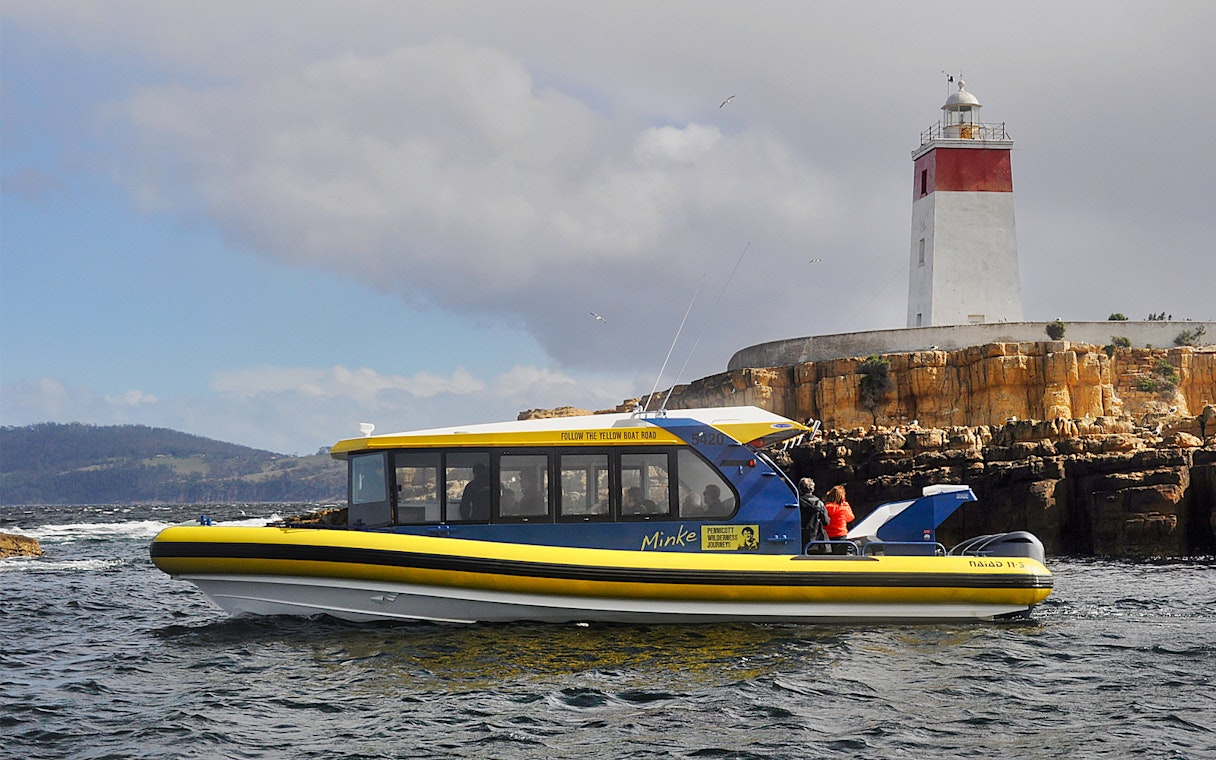 Boat cruising near Iron Pot Lighthouse, Tasmania.
