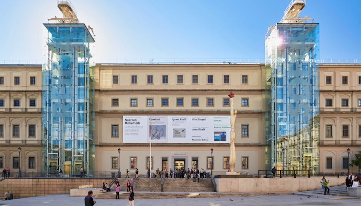 Reina Sofía Museum entrance with visitors on a guided tour in Madrid, Spain.