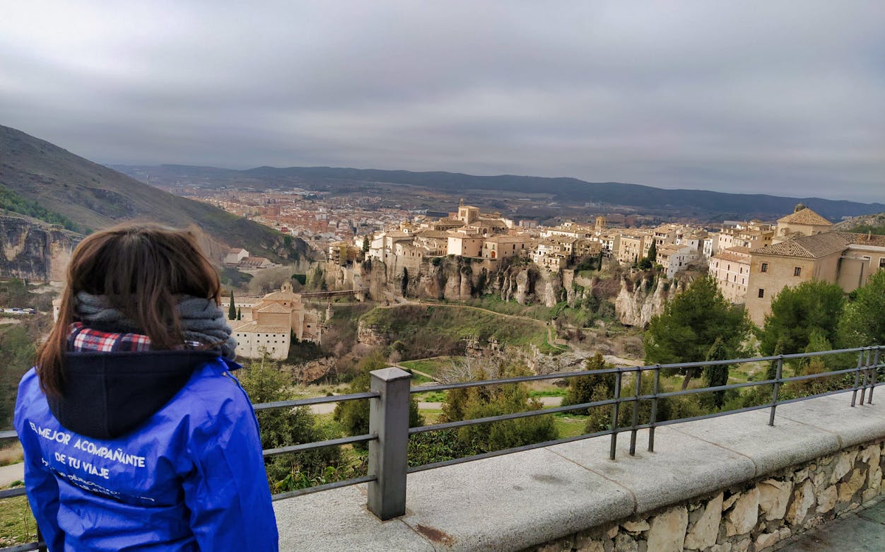 Tourist overlooking the historic cityscape of Cuenca during a guided tour from Madrid.