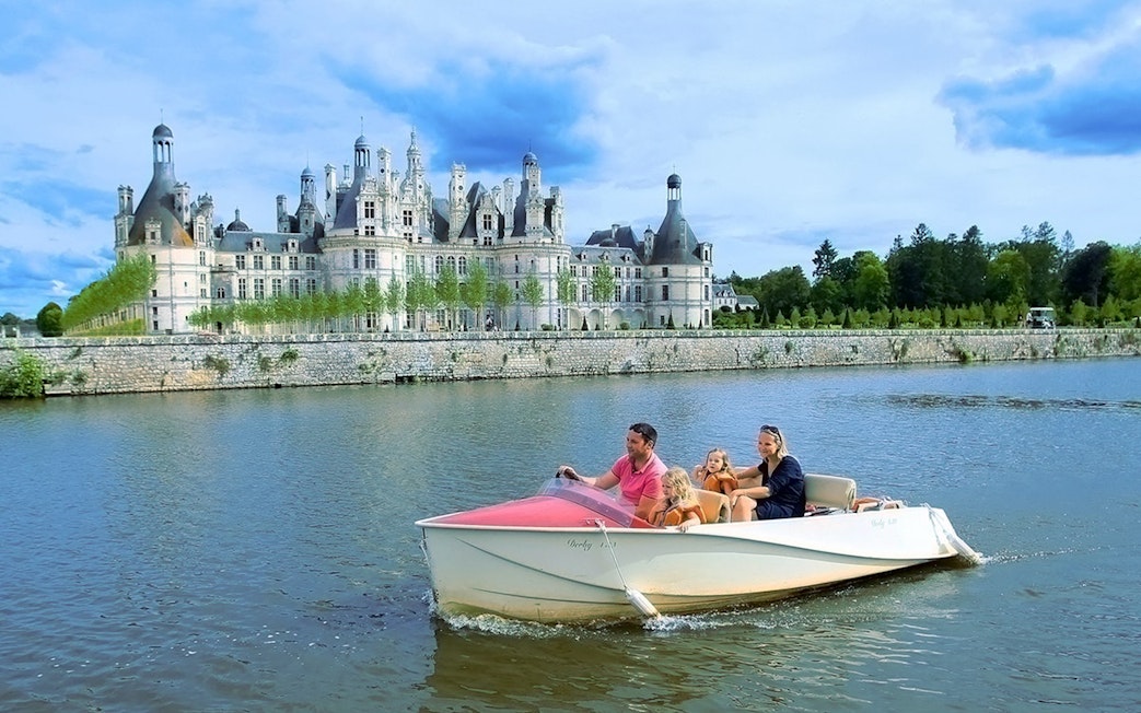 Family boating near Chambord Castle, France.