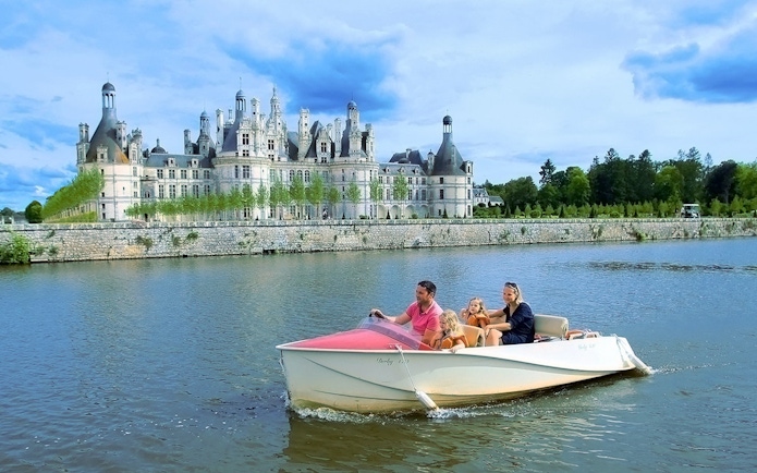 Family boating near Chambord Castle, France.
