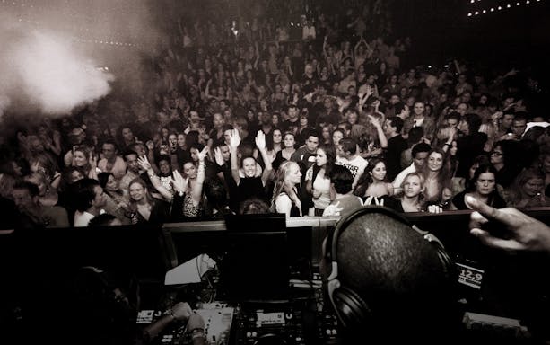 Crowd enjoying a DJ performance at a lively Amsterdam night event.