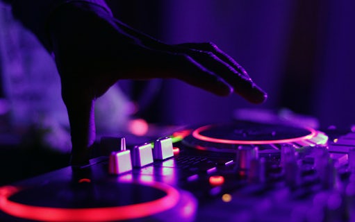 DJ mixing music at Amsterdam Surprise Night Dinner event.