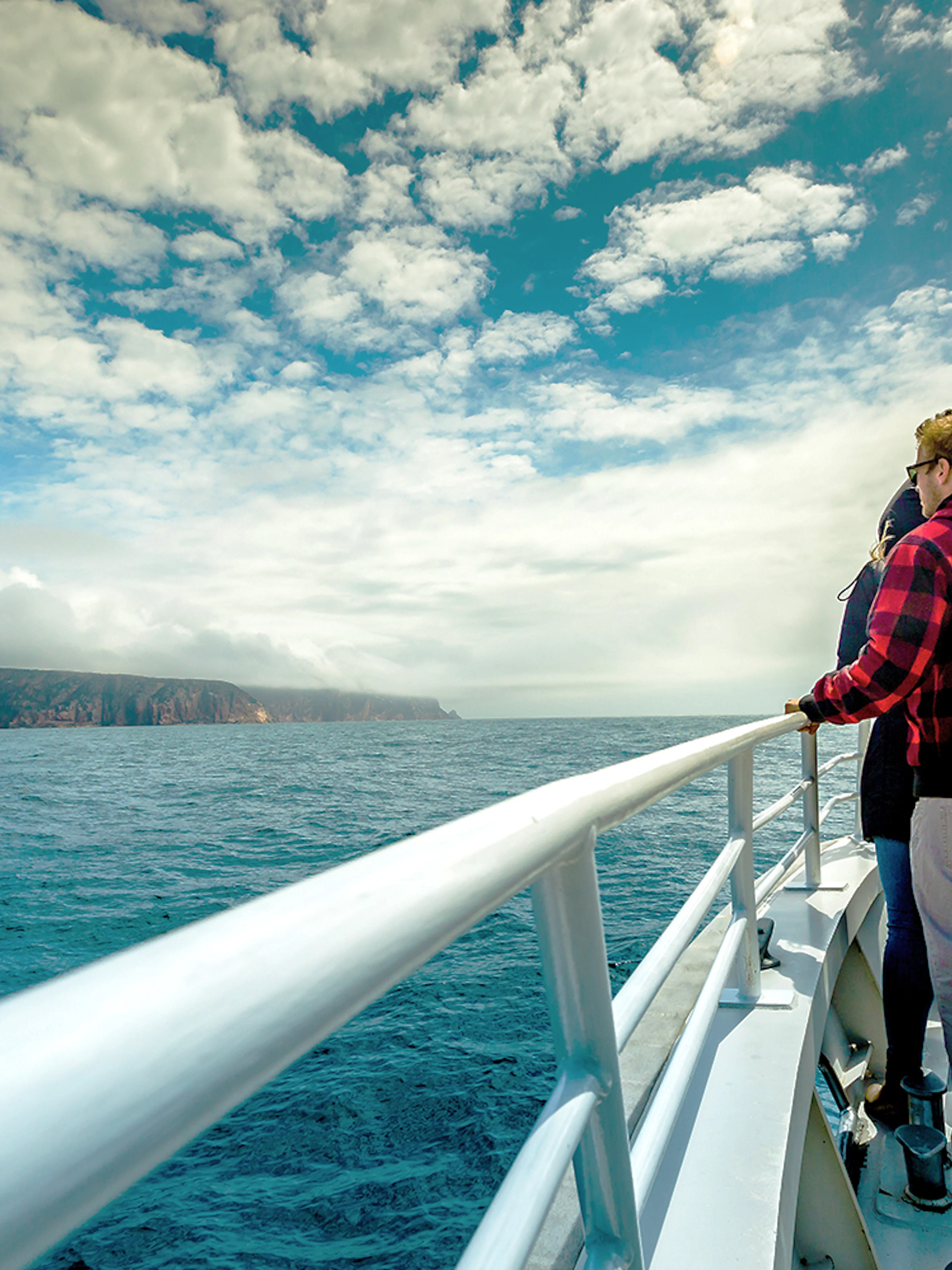 Tourists on a Wineglass Bay cruise boat viewing the coastline of Tasmania.