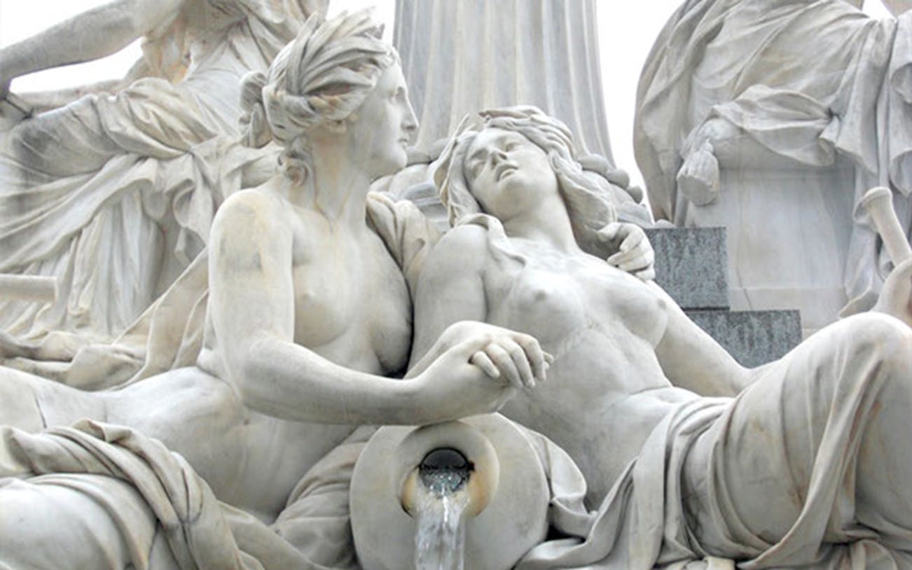 Marble statue of two intertwined figures with flowing water, Vienna.