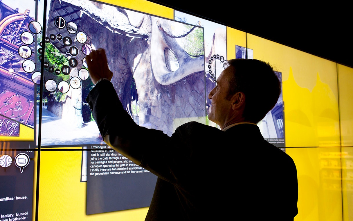 Man interacting with digital display at Gaudí 4D Experience in Barcelona.