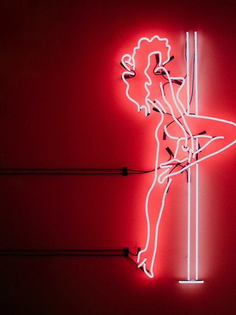 Neon silhouette of a dancer on a pole, part of the Tour de BonTon experience.