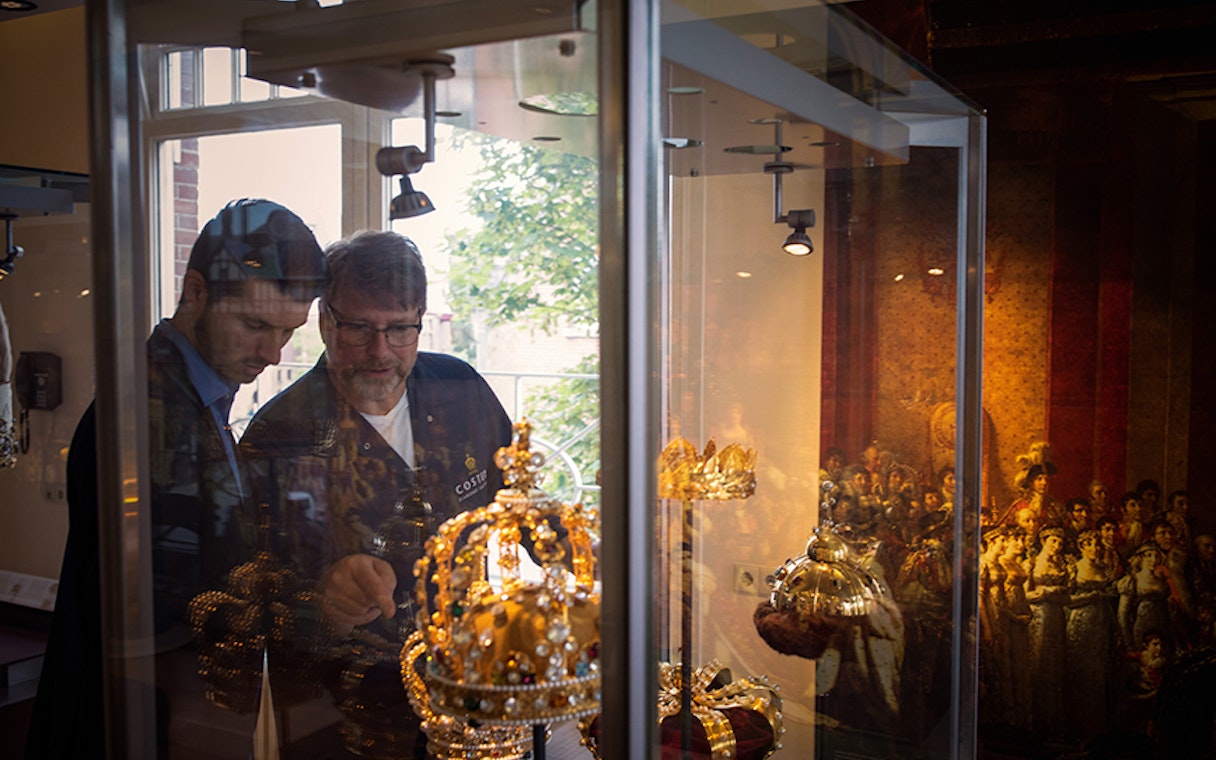 Visitors examining royal crowns at Diamond Museum Amsterdam.