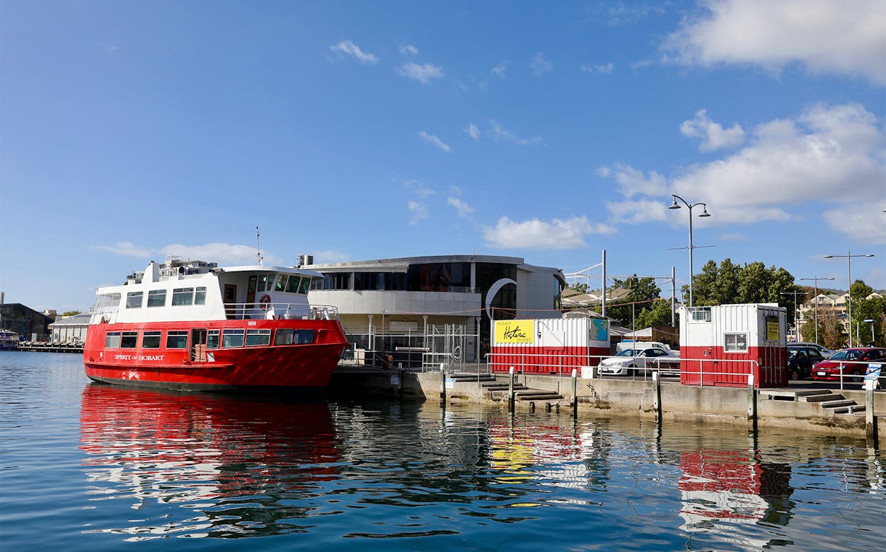 Red ferry docked at Hobart waterfront for historic lunch cruise.