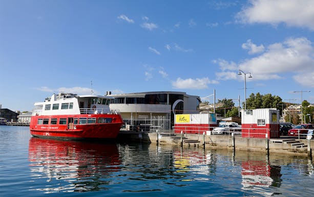 Red ferry docked at Hobart waterfront for historic lunch cruise.