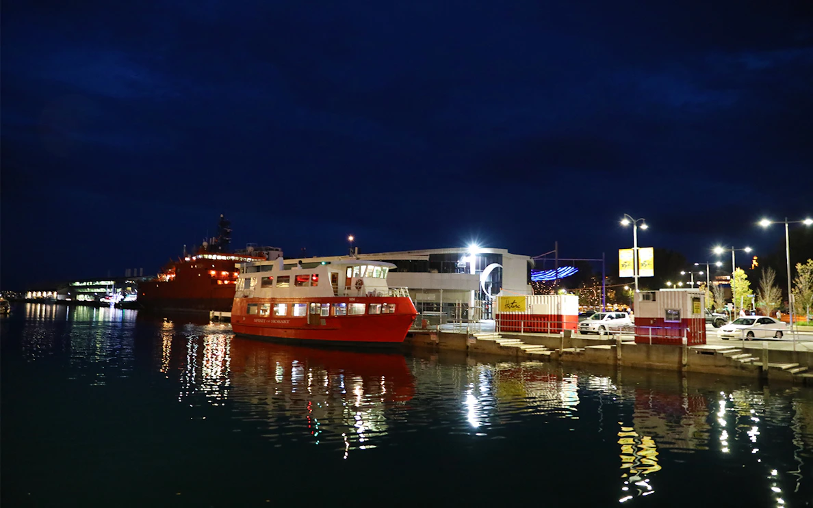 Red ferry docked at night for Hobart Historic Dinner Cruise, Tasmania.