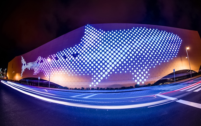 Exterior of Poema del Mar Aquarium with illuminated whale shark design, Las Palmas.