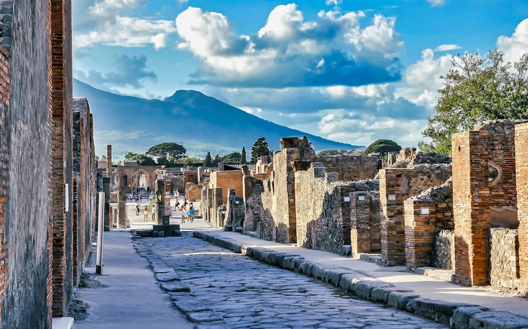 Ancient street in Pompeii with Mount Vesuvius in the background.