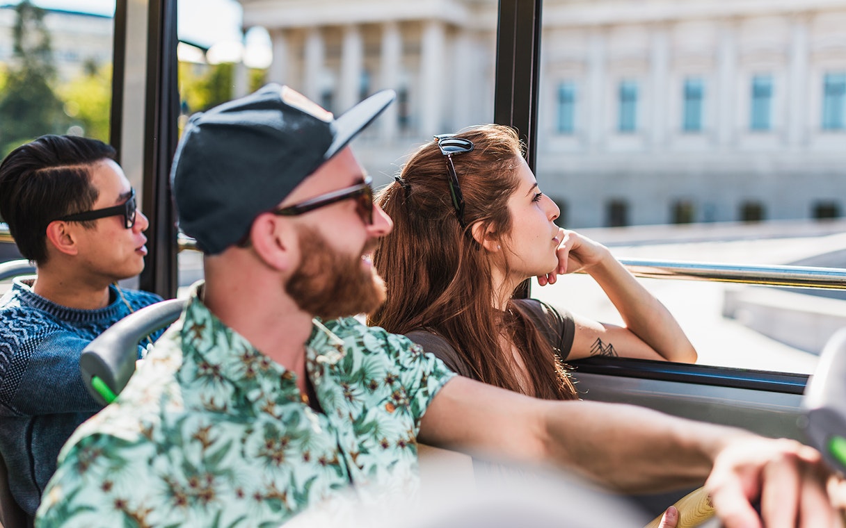 Tourists enjoying a Hop On Hop Off bus tour in Vienna.