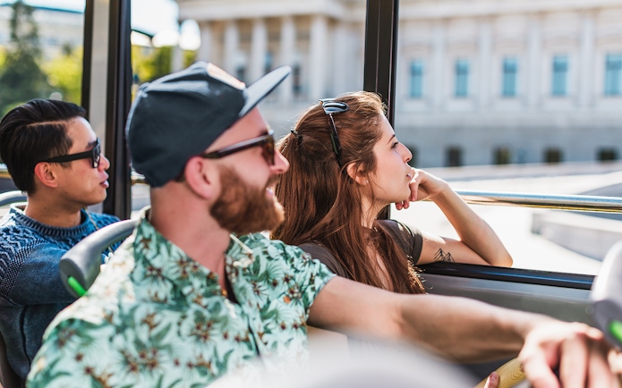 Tourists enjoying a Hop On Hop Off bus tour in Vienna.