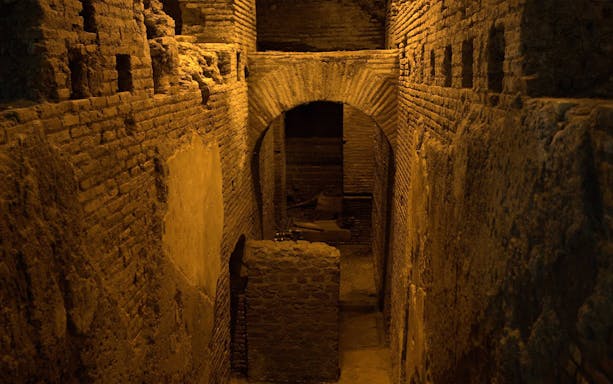 Underground Roman Catacombs with ancient brick walls and archway.