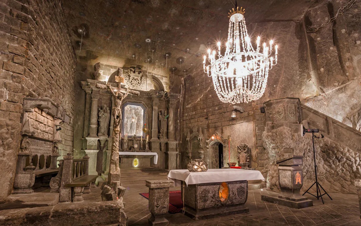 Underground chapel with stone altar and chandelier in Wieliczka Salt Mine, Poland.