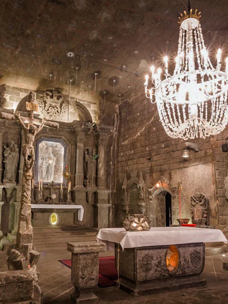 Underground chapel with stone altar and chandelier in Wieliczka Salt Mine, Poland.