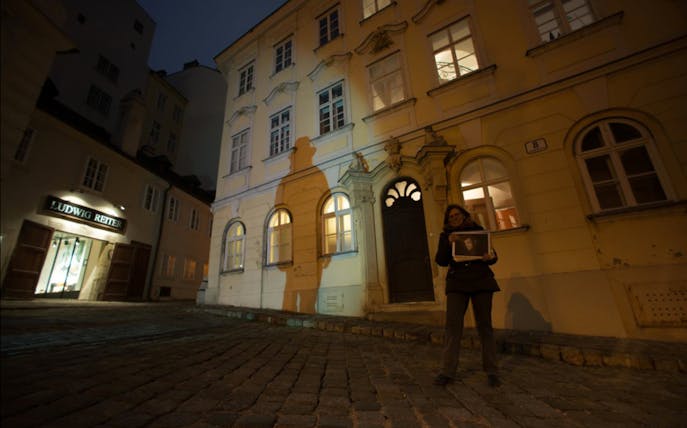 Tour guide holding a photo at a Vienna location from "The Third Man" film.