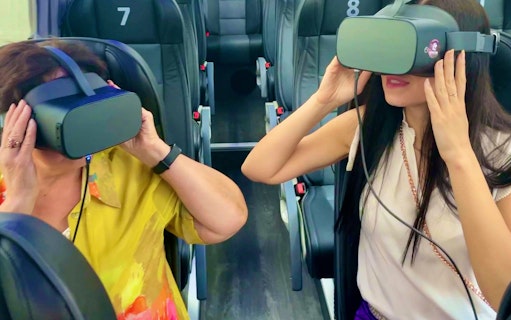 People using virtual reality headsets on a bus tour in Vienna.