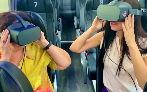 People using virtual reality headsets on a bus tour in Vienna.