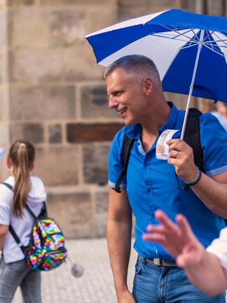 Tourists near Prague's Astronomical Clock, one holding cruise tickets.