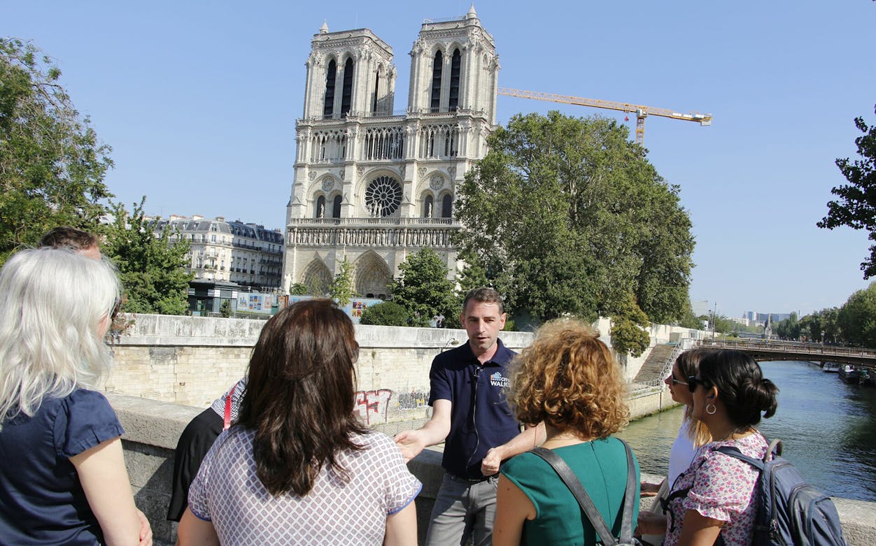 Tour group listening to a guide near Notre-Dame Cathedral, Paris.