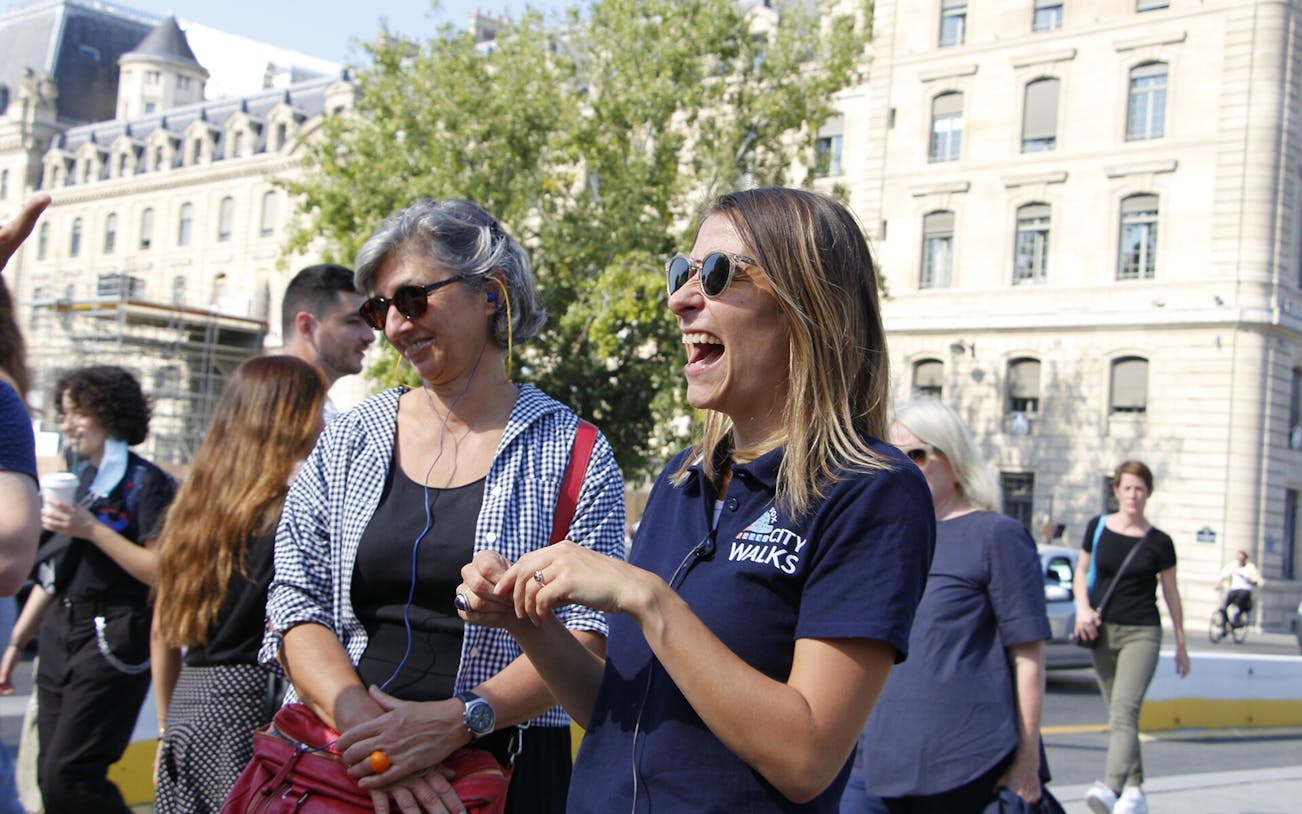 Tour guide leading a group on a Paris walking tour near historic buildings.