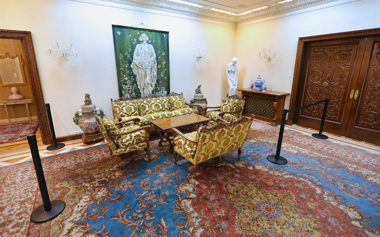 Elegant room in Ceausescu Mansion with ornate furniture and artwork, part of guided tour.