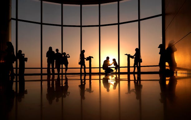 People enjoying sunset views from Burj Khalifa observation deck, Dubai.
