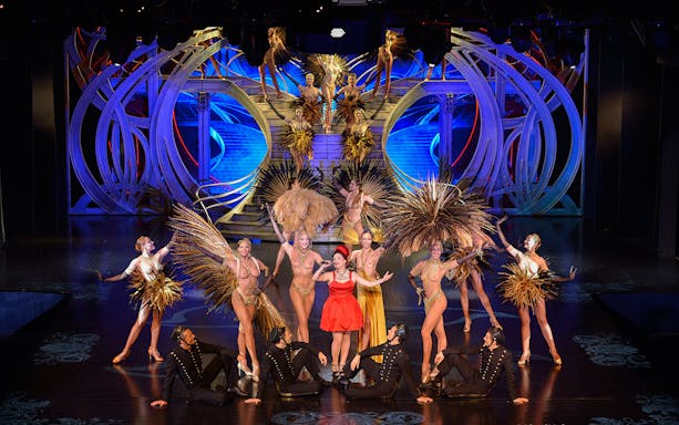 Performers in elaborate costumes on stage at Lido de Paris Cabaret Show.