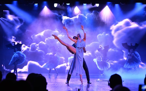 Dancers performing at Lido de Paris Cabaret Show with dramatic lighting and costumes.