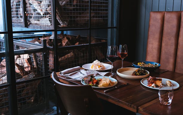 Wine and food pairing setup at City Winery with dishes and glasses on a wooden table.