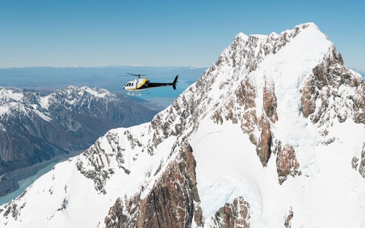 Helicopter flying over snow-covered Fox Glacier and Mount Cook, New Zealand.