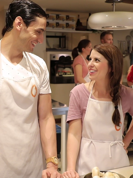 Small group cooking class in Florence kitchen, participants preparing dinner.