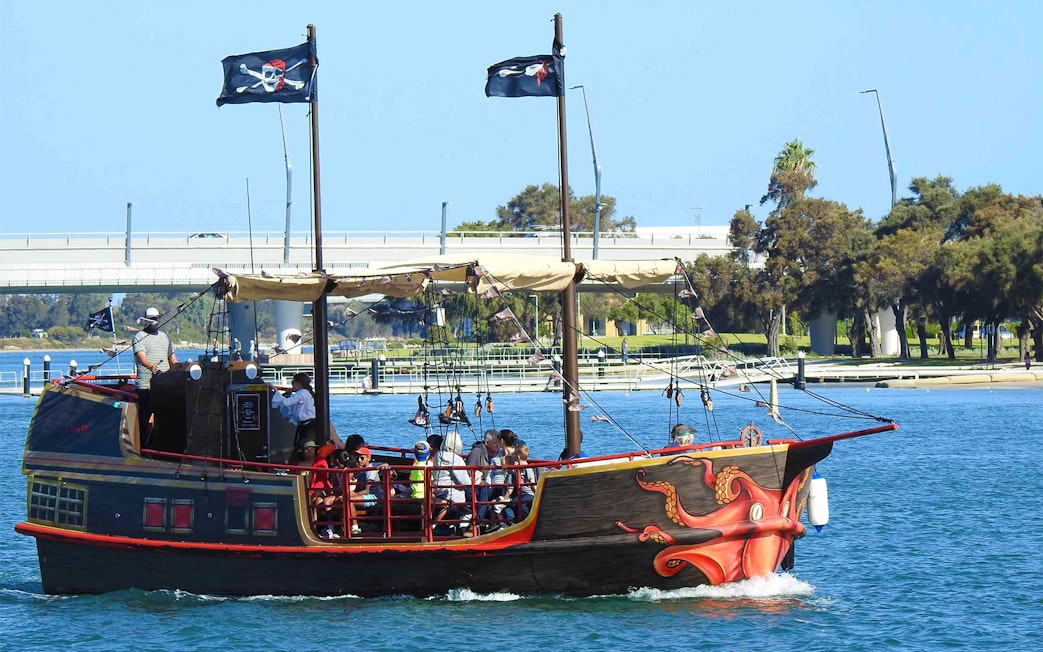 Pirate ship with passengers on Mandurah waters, featuring octopus design and pirate flags.