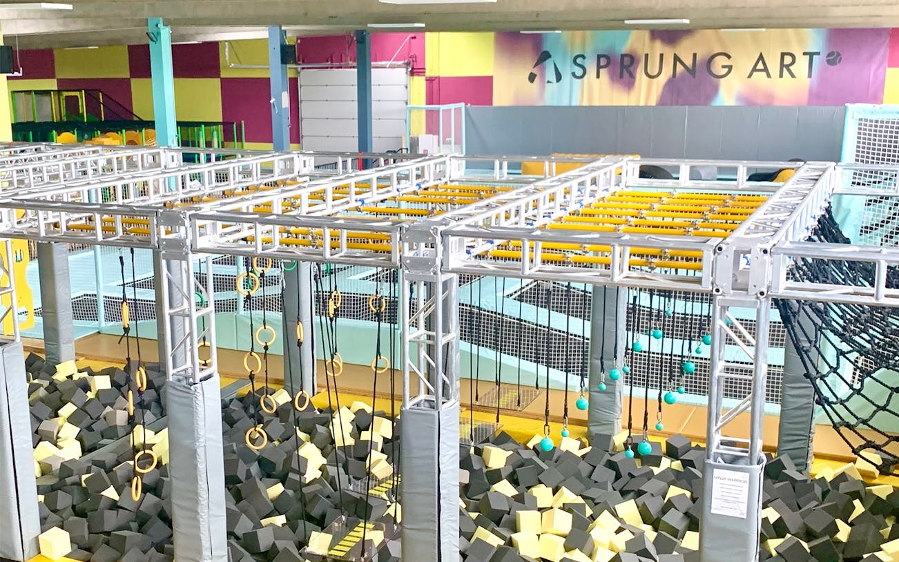 Indoor trampoline park with obstacle course and foam pit, featuring trampolinspringen activities.
