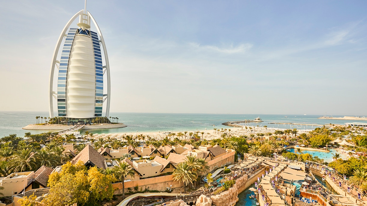 Wild Wadi Water Park with Burj Al Arab in Dubai, view of water slides and beach.