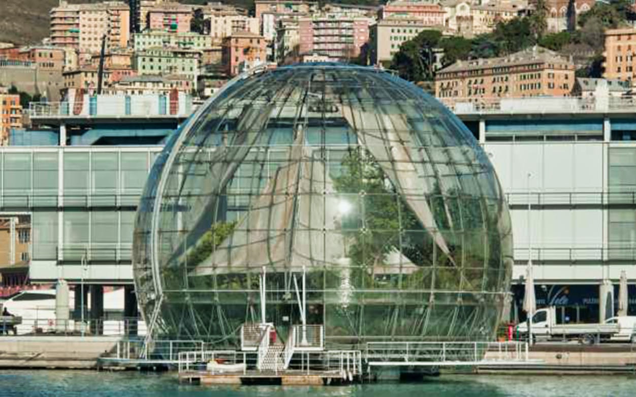 Biosfera glass dome in Genoa, Italy, with cityscape in the background.