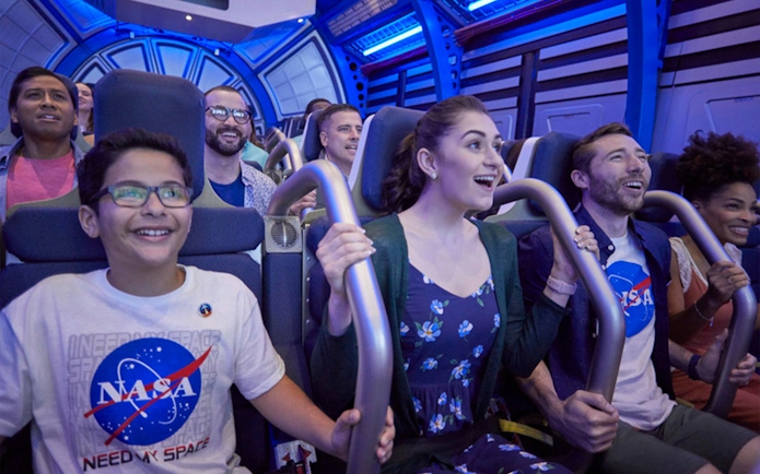 Visitors experiencing simulated shuttle cabin at Kennedy Space Center.