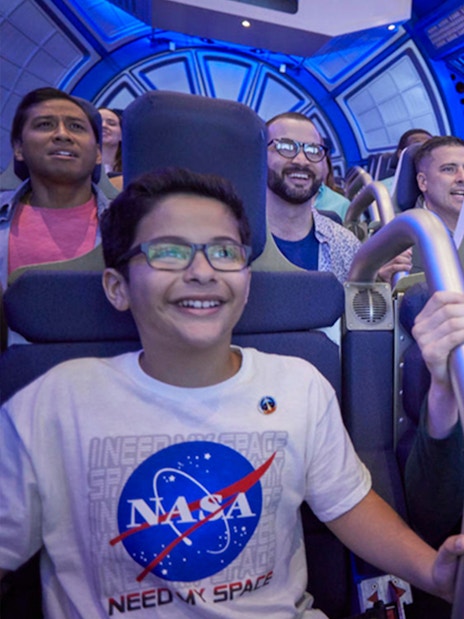 Visitors experiencing simulated shuttle cabin at Kennedy Space Center.