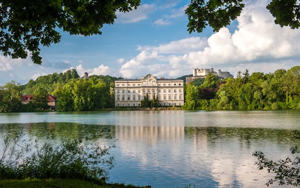 Schloss Leopoldskron by a lake with Hohensalzburg Fortress in Salzburg.