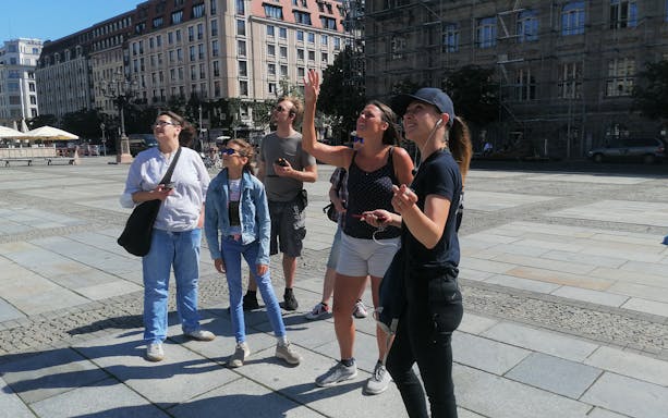 Group of tourists on a guided walking tour in Berlin city square.