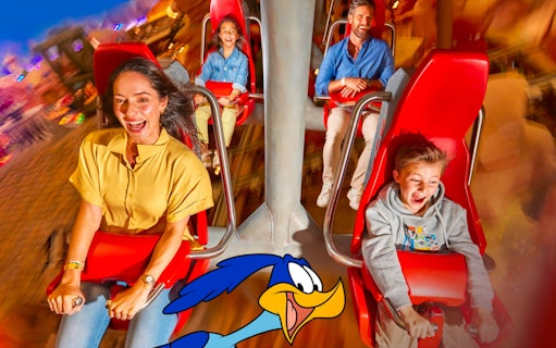 Visitors enjoying a thrilling ride at Warner Bros. World Abu Dhabi with Road Runner character.