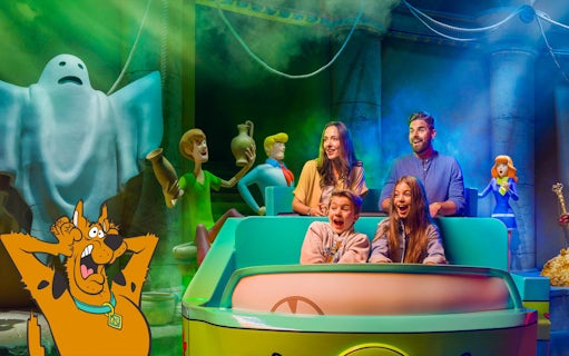 Visitors on a Scooby-Doo themed ride at Warner Bros, surrounded by animated characters and spooky decor.