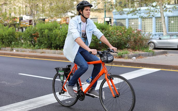 Cyclist on orange bike in Central Park, New York City.